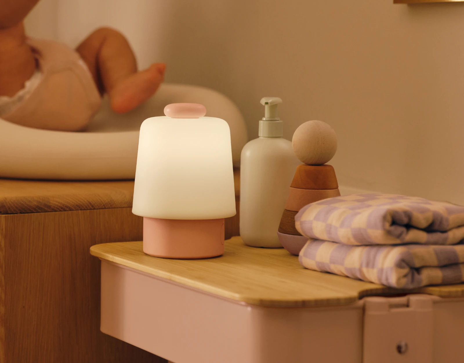 Hatch Baby Peach sitting on a nursery changing table