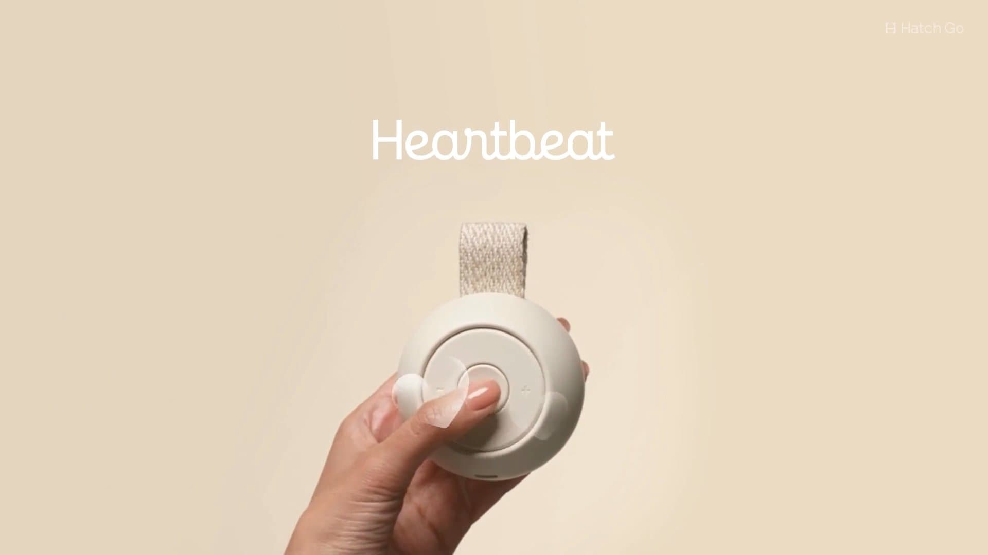 Hatch Go attached to a stroller with a hand pushing the button to scroll through sleep sounds